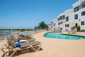 a couple of lounge chairs next to a swimming pool at Luxe Beach Resort in Discovery Bay