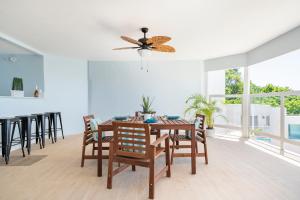 ein Esszimmer mit einem Tisch und Stühlen sowie einem Deckenventilator in der Unterkunft Luxe Beach Resort in Discovery Bay