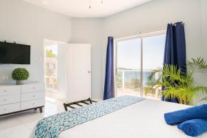 sypialnia z łóżkiem i dużym oknem w obiekcie Luxe Beach Resort w mieście Discovery Bay