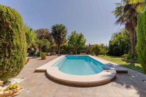 una piscina en medio de un patio con árboles en Casa Rural Rizao, en Nigüelas