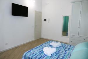a white bedroom with two white towels on a bed at Vico 18 in Gaeta