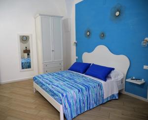 a blue bedroom with a bed with blue walls at Vico 18 in Gaeta