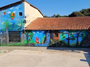 a mural on the side of a building with trees and fish at Pousada Kart Clube in São João del Rei