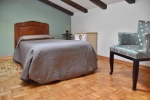 1 dormitorio con 1 cama y 1 silla en Vecchie Tre Colonne, en Cividale del Friuli