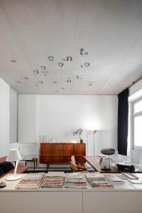 une chambre blanche avec une table et des livres dans l'établissement Casa do Conto - Arts & Residence, à Porto