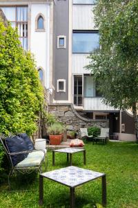 un jardín con mesa y 2 sillas y un edificio en Casa do Conto - Arts & Residence, en Oporto