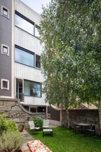 um edifício com uma mesa e cadeiras num quintal em Casa do Conto - Arts & Residence no Porto