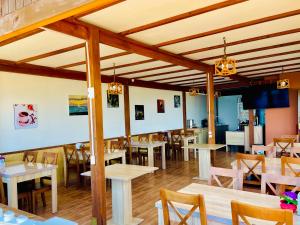 a restaurant with tables and chairs in a room at Sea Line Hotel in Shekhvetili
