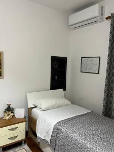 1 Schlafzimmer mit 2 Einzelbetten, einem Nachttisch und einem m2 großen Bett in der Unterkunft Cozy Nest Ledi in Tirana