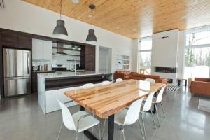 a kitchen and dining room with a wooden table and chairs at Le Vaillant du Massif in Petite-Rivière-Saint-François