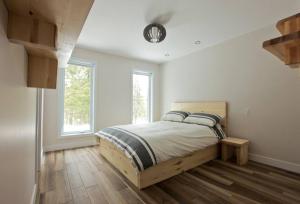 - une chambre avec un lit et une horloge au plafond dans l'établissement Le Vaillant du Massif, à Petite-Rivière-Saint-François
