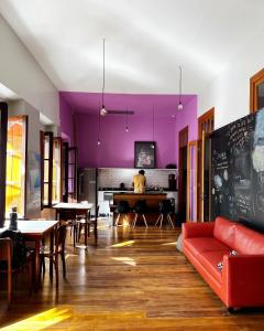 een man aan een tafel in een kamer met paarse muren bij Hostel Matilda in Curitiba