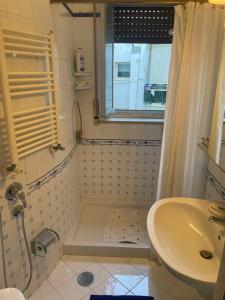ein kleines Bad mit einem Waschbecken und einer Dusche in der Unterkunft Panoramico a Posillipo in Neapel
