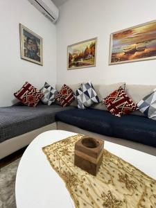 ein Wohnzimmer mit einem blauen Sofa und einem Tisch in der Unterkunft Cozy Nest Ledi in Tirana