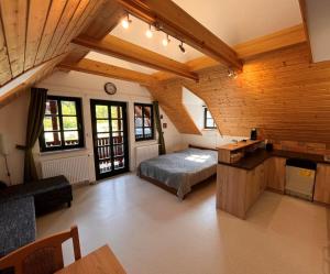 HOFBERG Apartmán في Nové Hamry: غرفة نوم بسرير في غرفة بسقوف خشبية