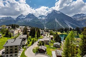 a town in the mountains with a lake and mountains at Pension Arosa - Self Check-In in Arosa