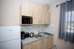 uma pequena cozinha com um lavatório e um frigorífico em GreKa apartments em Kalivia Poligirou