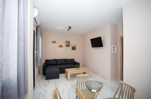 sala de estar con sofá negro y mesa en GreKa apartments, en Kalivia Poligirou