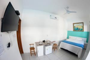 Villa Salgada Maresias في ماريسياز: غرفة نوم صغيرة بها سرير وتلفزيون