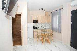 uma cozinha com uma pequena mesa e uma cozinha com paredes brancas em GreKa apartments em Kalivia Poligirou