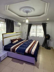 a bedroom with a bed in a room with windows at 3 Bedrooms Duplex in Ibadan