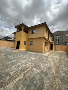 a large yellow house with a large driveway at 3 Bedrooms Duplex in Ibadan