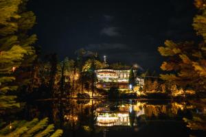 een huis op een heuvel boven een meer 's nachts bij Hotel Estalagem St. Hubertus in Gramado