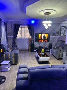 sala de estar con sofás y techo azul en 3 Bedrooms Duplex, en Ibadán