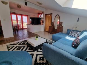 a living room with two blue couches and a table at Apartments Paradiso in Pula