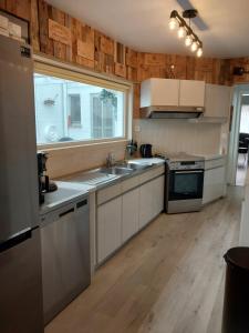 a kitchen with white cabinets and a sink and a window at Repos St Elisabeth nabij Plopsaland in De Panne