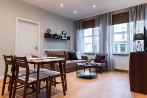 sala de estar con mesa y sofá en Friends and Family Vacation Apartments, en Riga