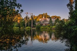 グラマドにあるHotel Estalagem St. Hubertusの湖畔に座る大家