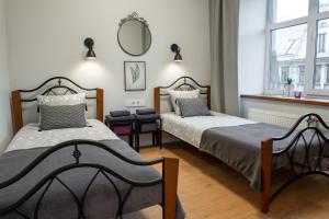 1 dormitorio con 2 camas y espejo en la pared en Friends and Family Vacation Apartments en Riga