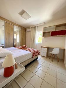 a bedroom with two beds and a table and a lamp at Casa de praia no Flamengo in Salvador