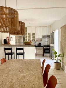 a kitchen with a table and chairs in a room at Casa de praia no Flamengo in Salvador