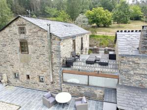 an external view of a stone building with a patio at Casa Piñeiro in Monfero