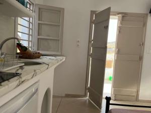 a white kitchen with a sink and a shower at AmatoNostro in Mandrakia +35 photos