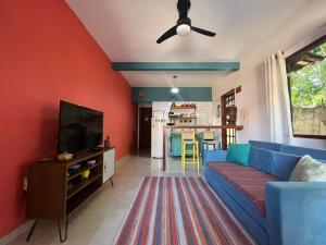 sala de estar con sofá azul y TV en Apartamento Chapada Diamantina, en Lençóis
