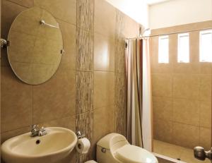 a bathroom with a sink and a toilet and a mirror at Casa Hotel Mamaluna in Lunahuaná