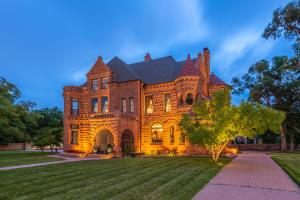 une grande maison en briques avec un arbre en face de celle-ci dans l'établissement Orman Mansion - Pueblo's Most Luxurious Stay!, à Pueblo