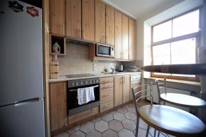 a kitchen with wooden cabinets and a table and chairs at Old town 2 bedroom / Top location in Rīga