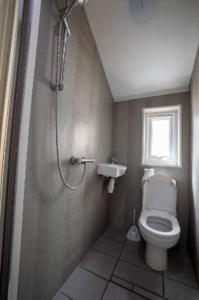 a bathroom with a shower and a toilet and a window at Abingdon House Workstays UK in Middlesbrough