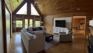 ein Wohnzimmer mit 2 Sofas und einem TV in der Unterkunft Lakefront-Private-Huge Log Cabin 