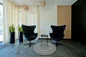 3 sillas negras y una mesa en una habitación en BlueApart Apartamenty Portowa, en Jastarnia