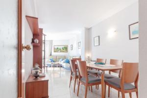 a dining room and living room with a table and chairs at Fantástico apartamento en la playa. A/A y vistas in Pineda de Mar