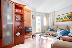 a living room with a couch and a table at Fantástico apartamento en la playa. A/A y vistas in Pineda de Mar
