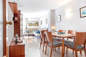 a living room with a table and chairs and a couch at Fantástico apartamento en la playa. A/A y vistas in Pineda de Mar +11 photos