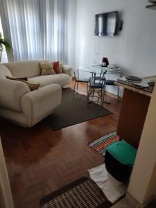 a living room with a couch and a table at Apartamento 2 dormitórios, wifi, ponta da praia, predio em frente ao mar - Santos in Santos +15 photos