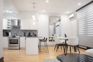cocina y sala de estar con mesa y sillas en Luxurious Modern Royalty in Plateau Mont-Royal - 3, en Montreal