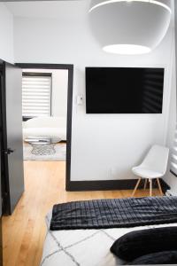 1 dormitorio con espejo grande y TV en Luxurious Modern Royalty in Plateau Mont-Royal - 3, en Montreal
